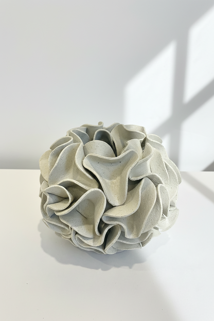 Decorative ceramic vase with ruffled texture on natural white clay