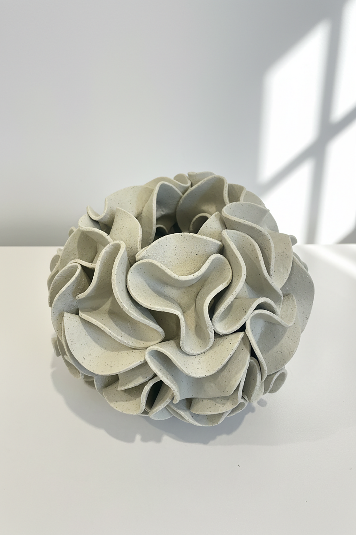 Decorative ceramic vase with ruffled texture on natural white clay