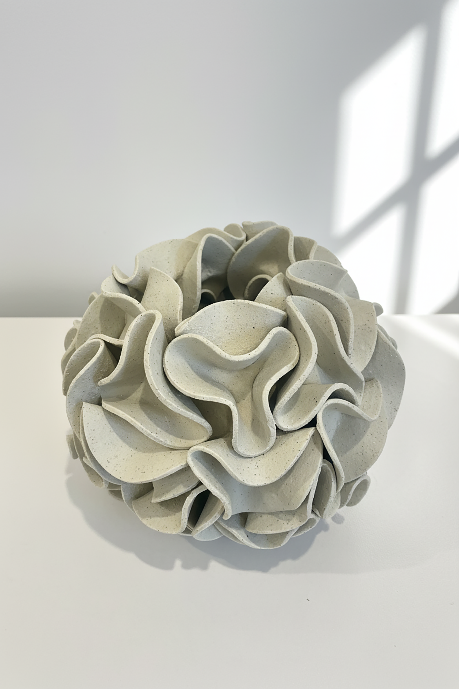 Decorative ceramic vase with ruffled texture on natural white clay