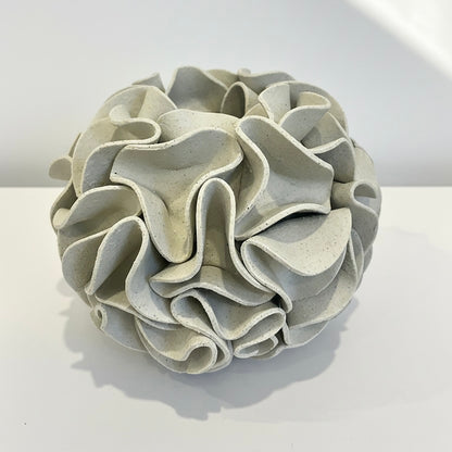 Decorative sphere vase with ruffled texture on natural white clay