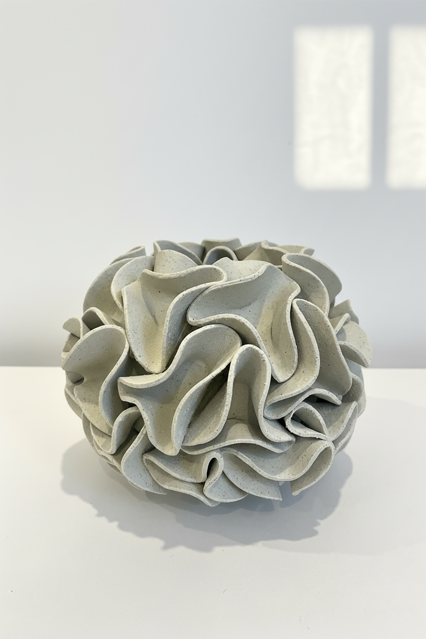 Decorative ceramic vase with ruffled texture on natural white clay