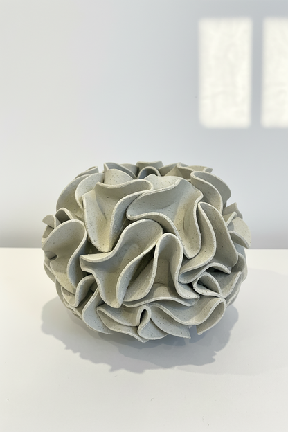 Decorative ceramic vase with ruffled texture on natural white clay