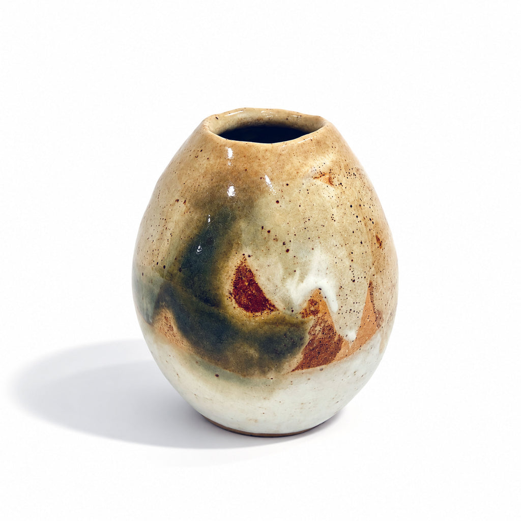 A small handmade ceramic vase with a rounded, bulbous shape and an irregular hand-painted glaze featuring beige, brown, dark green, and reddish accents, set against a plain white background.