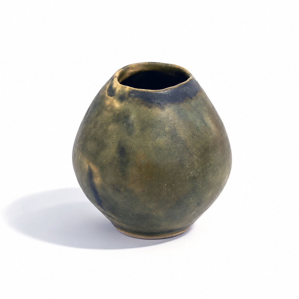 A small rounded ceramic vase with a wide opening, featuring a mottled earthy green and brown glaze with dark blue-brown accents near the rim, set against a plain white background.